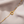 Gold bracelet with interlocking rings on a beige fabric background