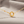 Gold necklace with interlocking rings on a soft fabric background