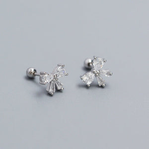 A set of bowknot screw back stud earrings in silver and gold colors.