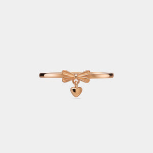 Rose gold bracelet with bow and heart charm on a light gray background