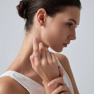 Woman wearing a silver ring on her finger against a neutral background