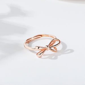 Two rings, one with a rose gold finish and the other with a silver finish, both featuring a bow knot design.