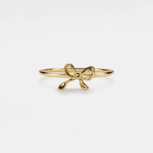 Gold bow-shaped ring on a white background