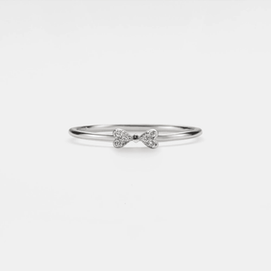 A thin stacking ring with a bow knot design, featuring gold plating and small inset cubic zirconia stones, on a white background.