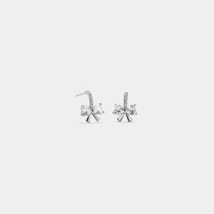 Pair of silver earrings with clear gemstones on a light gray background