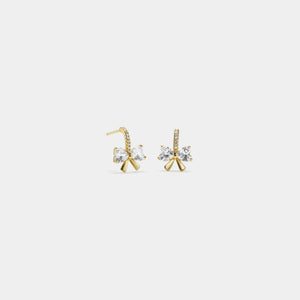 Gold earrings with clear gemstones on a light gray background