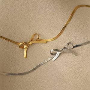 Gold and silver ribbons tied into bows on a beige background