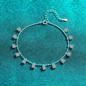 Silver bracelet with diamond-like charms on a teal background