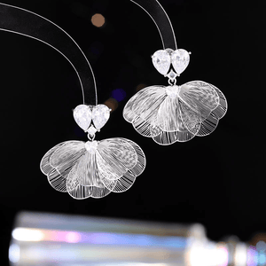 Silver floral earrings on a black background
