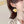 Close-up of a person wearing yellow flower-shaped earrings with a neutral background