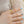 Gold flower ring on a finger with light blue nail polish