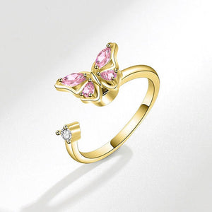Gold ring with pink gemstones on a white background