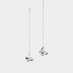Butterfly-shaped earrings on thin chains against a white background