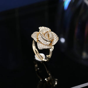 Gold rose-shaped ring with diamonds on a black background