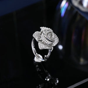 Silver ring with rose design on a dark background