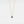 Gold necklace with a blue gemstone pendant on a light gray background