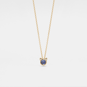 Gold necklace with a blue gemstone pendant on a light gray background