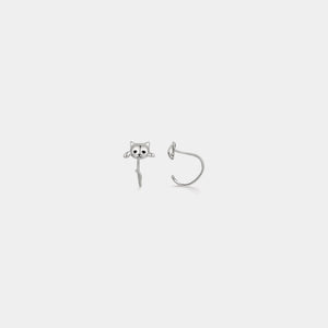 Silver skull-shaped earring on a white background