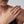 Gold ring on a hand with a neutral background
