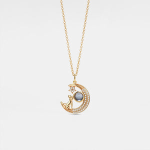 Gold necklace with a moon and star pendant on a light gray background