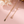 Gold chain necklace on a pink background with floral elements