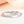 Silver ring with pink flower and white butterfly design on a light background