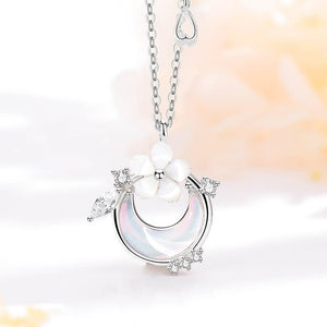 Silver necklace with a moon-shaped pendant and pearl on a soft background