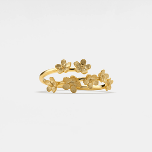 Gold floral ring on a light gray background
