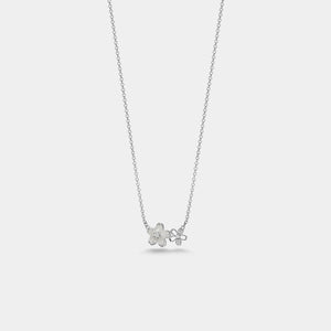 Silver necklace with a floral pendant on a light gray background