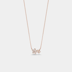 Rose gold necklace with a floral pendant on a light gray background