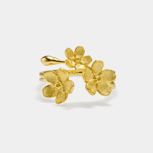Gold floral earrings on a white background