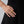 Gold ring on a person's finger against a black background