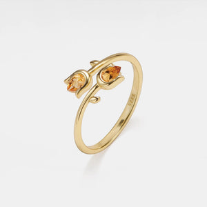 Gold ring with two embedded stones on a white background