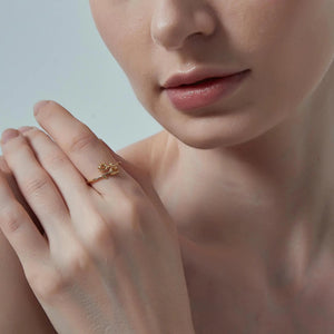 Close-up of a hand wearing a gold ring with a blurred background