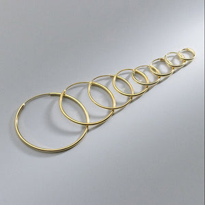 Set of gold hoop earrings on a gray background