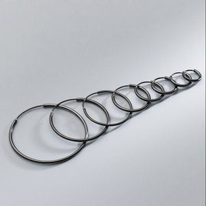 Set of black hoop earrings on a gray background