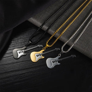 Three guitar-shaped pendants on chains against a dark fabric background