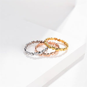 Three gold rings of different designs on a white background