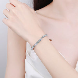 Silver bracelet on a person's wrist with a plain background