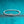 Silver bracelet with clear stones on a teal glittery background