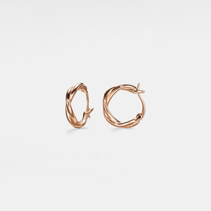 A pair of rose gold-plated twisted rope hoop earrings on a white background