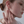 A model wearing gold-plated twisted rope hoop earrings on a white background