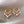 Gold hoop earrings with pearl drops on a beige fabric background