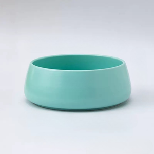 Turquoise ceramic bowl on a light gray background