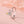Butterfly-shaped ring with colorful gemstones on a soft pink background