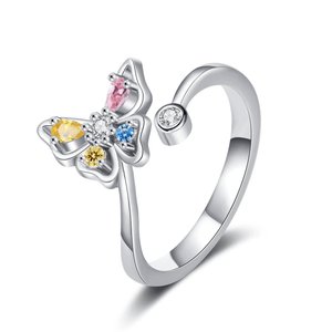 Butterfly-shaped ring with colorful gemstones on a white background