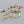Gold earrings with colorful gemstones on a gray background