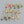 Gold hoop earrings with colorful gemstones on a gray background
