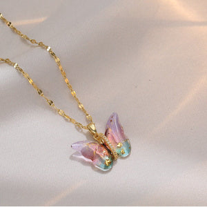 A collection of butterfly pendant necklaces with gold and silver chains and multicolored gemstone butterflies.