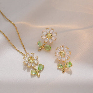 Floral jewelry set with gold chain, pendant, and earrings on a light background